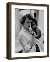 Nurse Holding African American Girl in Her Arms, Examining Her Finger-John Dominis-Framed Photographic Print