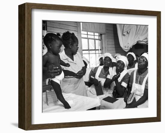 Nurse/Midwife Maude Callen Holds Baby and Teaches Class in Midwifery How to Look for Abnormalities-W^ Eugene Smith-Framed Premium Photographic Print