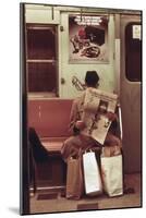 NYC Subway Passenger Reading Newspaper with Shopping Bags in May 1973-null-Mounted Photo