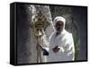 Old Ethiopian Orthodox Priest Holds a Large Brass Coptic Cross at Rock-Hewn Church of Adadi Maryam-Nigel Pavitt-Framed Stretched Canvas