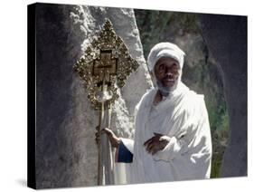 Old Ethiopian Orthodox Priest Holds a Large Brass Coptic Cross at Rock-Hewn Church of Adadi Maryam-Nigel Pavitt-Stretched Canvas