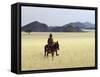 Old Himba Woman, Upright Despite Her Years, Rides Her Donkey Through Harsh Land-Nigel Pavitt-Framed Stretched Canvas