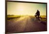 Old Man Riding A Bike On Asphalt Road Towards The Sunny Sunset Sky-Michal Bednarek-Framed Art Print
