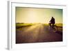 Old Man Riding A Bike On Asphalt Road Towards The Sunny Sunset Sky-Michal Bednarek-Framed Art Print