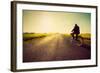 Old Man Riding A Bike On Asphalt Road Towards The Sunny Sunset Sky-Michal Bednarek-Framed Art Print