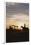 Old West, New West, Man Sitting on Horse with Oil Refinery at Sunset-David R^ Frazier-Framed Photographic Print