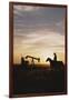 Old West, New West, Man Sitting on Horse with Oil Refinery at Sunset-David R^ Frazier-Framed Photographic Print