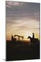 Old West, New West, Man Sitting on Horse with Oil Refinery at Sunset-David R^ Frazier-Mounted Photographic Print