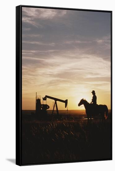 Old West, New West, Man Sitting on Horse with Oil Refinery at Sunset-David R^ Frazier-Framed Stretched Canvas