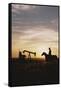 Old West, New West, Man Sitting on Horse with Oil Refinery at Sunset-David R^ Frazier-Framed Stretched Canvas