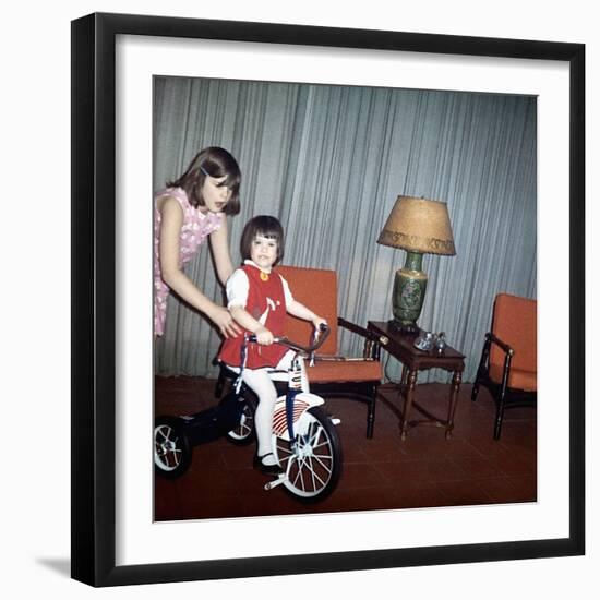 Older Sister Helps Her Sister with New Bike, Ca. 1967-null-Framed Photographic Print