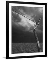 On a Small Farm, Ominous Clouds Overhead, Outlined by Barbed Wire Fencing-Nat Farbman-Framed Photographic Print