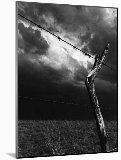 On a Small Farm, Ominous Clouds Overhead, Outlined by Barbed Wire Fencing-Nat Farbman-Mounted Photographic Print