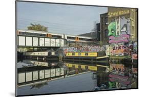 Overground train drives past canal by artists studios and warehouses in Hackney Wick, London, Engla-Julio Etchart-Mounted Photographic Print