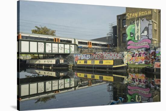 Overground train drives past canal by artists studios and warehouses in Hackney Wick, London, Engla-Julio Etchart-Stretched Canvas