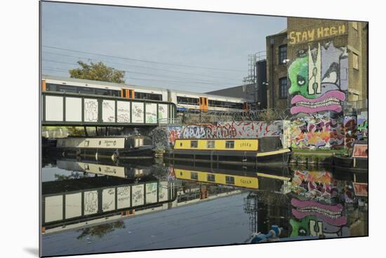 Overground train drives past canal by artists studios and warehouses in Hackney Wick, London, Engla-Julio Etchart-Mounted Photographic Print