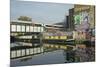 Overground train drives past canal by artists studios and warehouses in Hackney Wick, London, Engla-Julio Etchart-Mounted Photographic Print