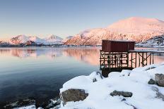 Fishing Hut on Stilts on a Pier, Winter Landscape in a Fjord in Front of Snowy Mountains-P. Kaczynski-Photographic Print