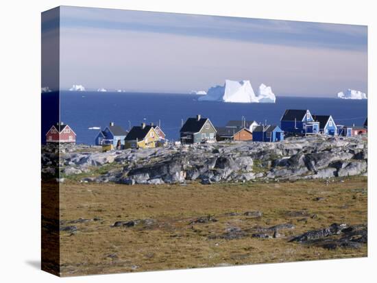 Painted Village Houses in Front of Icebergs in Disko Bay, West Coast, Greenland-Anthony Waltham-Stretched Canvas