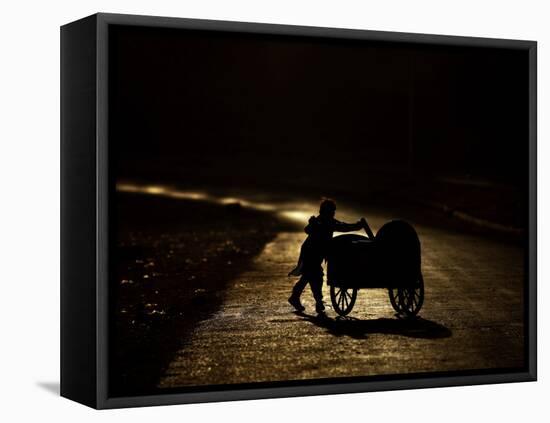 Pakistani Boy Pushes a Cart Along the Main Street in Rawalpindi, Pakistan-null-Framed Stretched Canvas
