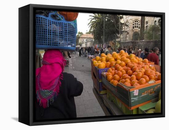 Palestinian Woman in Colourful Scarf and Carrying Bag on Her Head Walking Past an Orange Stall-Eitan Simanor-Framed Stretched Canvas