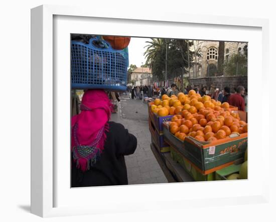 Palestinian Woman in Colourful Scarf and Carrying Bag on Her Head Walking Past an Orange Stall-Eitan Simanor-Framed Photographic Print