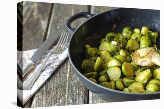 Pan-Fried Brussels Sprouts in Cast-Iron Frying Pan on Wooden Table-Jana Ihle-Stretched Canvas