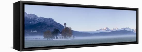 Panorama of St. Coloman Church surrounded by the autumn fog at sunrise, Schwangau, Bavaria, Germany-Roberto Moiola-Framed Stretched Canvas