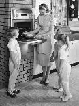 1950s MOTHER AND THREE DAUGHTERS STANDING AROUND OVEN IN KITCHEN BAKING PIE-Panoramic Images-Photographic Print