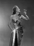 1950s WOMAN WEARING METALLIC EVENING GOWN HOLDING UP WINE GLASS PROFILE-Panoramic Images-Photographic Print