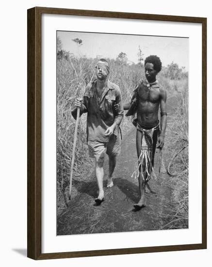 Papuan Native Helping a Wounded Australian Infantryman Along Road Away from the Buna Battlefront-George Silk-Framed Photographic Print