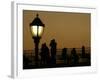 Passengers on a Ferry Pass a Street Lamp on the Waterfront at Battery Park-null-Framed Photographic Print