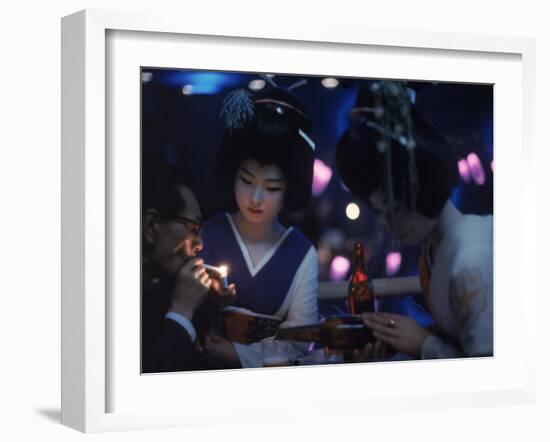 Patron of Nightclub Uruwashi Having His Cigarette Lit by Geisha-Eliot Elisofon-Framed Photographic Print