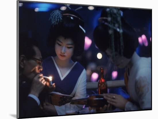 Patron of Nightclub Uruwashi Having His Cigarette Lit by Geisha-Eliot Elisofon-Mounted Photographic Print