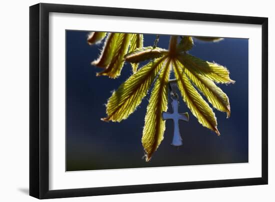 Pendant with cross on a young green chestnut leaf at springtime-null-Framed Giclee Print