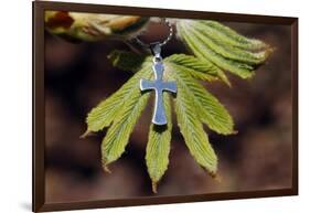 Pendant with cross on a young green chestnut leaf at springtime-null-Framed Giclee Print