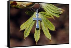 Pendant with cross on a young green chestnut leaf at springtime-null-Framed Stretched Canvas