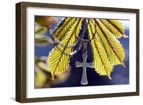 Pendant with cross on a young green chestnut leaf at springtime-null-Framed Giclee Print