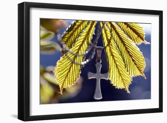 Pendant with cross on a young green chestnut leaf at springtime-null-Framed Giclee Print