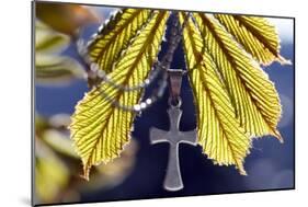 Pendant with cross on a young green chestnut leaf at springtime-null-Mounted Giclee Print