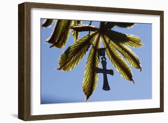 Pendant with cross on a young green chestnut leaf at springtime-null-Framed Giclee Print