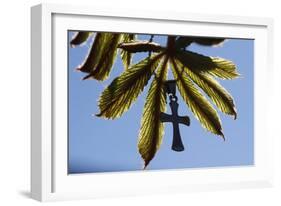 Pendant with cross on a young green chestnut leaf at springtime-null-Framed Giclee Print