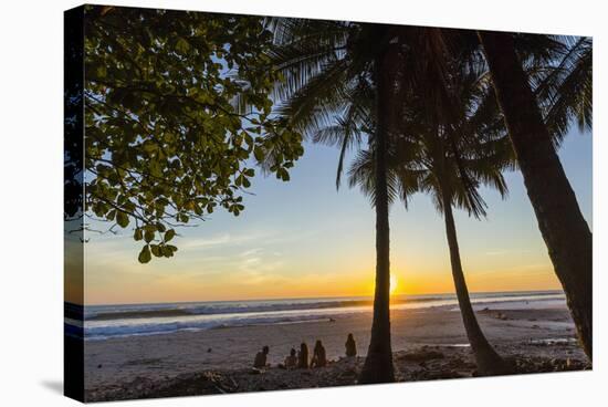 People by Palm Trees at Sunset on Playa Hermosa Beach, Santa Teresa, Costa Rica-Rob Francis-Stretched Canvas