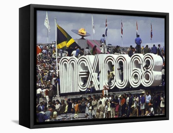 People Climbing and Sitting on a Mexico '68 Sign at the Summer Olympics-John Dominis-Framed Stretched Canvas