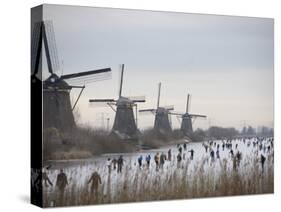 People Skate on Frozen Canals in Kinderdijk's Mill Area, a UNESCO World Heritage Site, Netherlands-null-Stretched Canvas