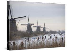 People Skate on Frozen Canals in Kinderdijk's Mill Area, a UNESCO World Heritage Site, Netherlands-null-Stretched Canvas