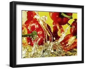 Peppers Falling into Water Against Yellow Background-Michael Meisen-Framed Photographic Print