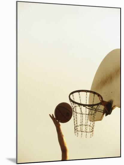 Person's Hand Holding a Basketball Near the Hoop-null-Mounted Photographic Print