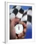 Person's Hand Holding a Stopwatch in Front of a Checkered Flag-null-Framed Photographic Print