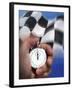 Person's Hand Holding a Stopwatch in Front of a Checkered Flag-null-Framed Photographic Print